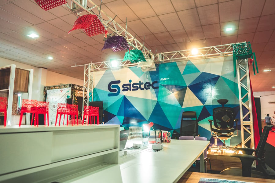 Estande da Sistec Móveis com exposição de cadeiras e mobiliário corporativo